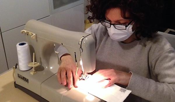 Una sarta del Teatro Regio di Torino al lavoro per realizzare una mascherina Una sarta del Teatro Regio di Torino al lavoro per realizzare una mascherina
